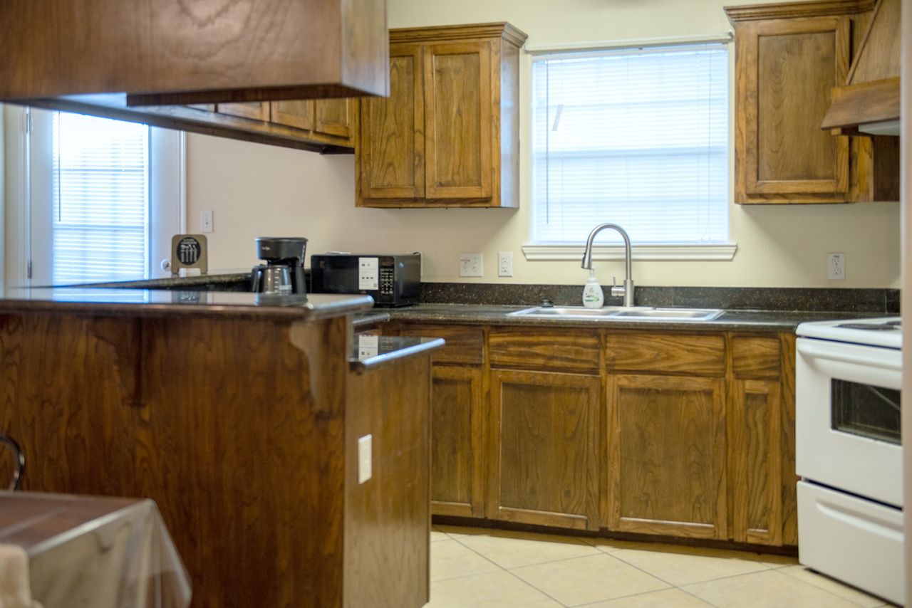 Kitchen with wood cabinets, granite counters, coffee maker and microwave