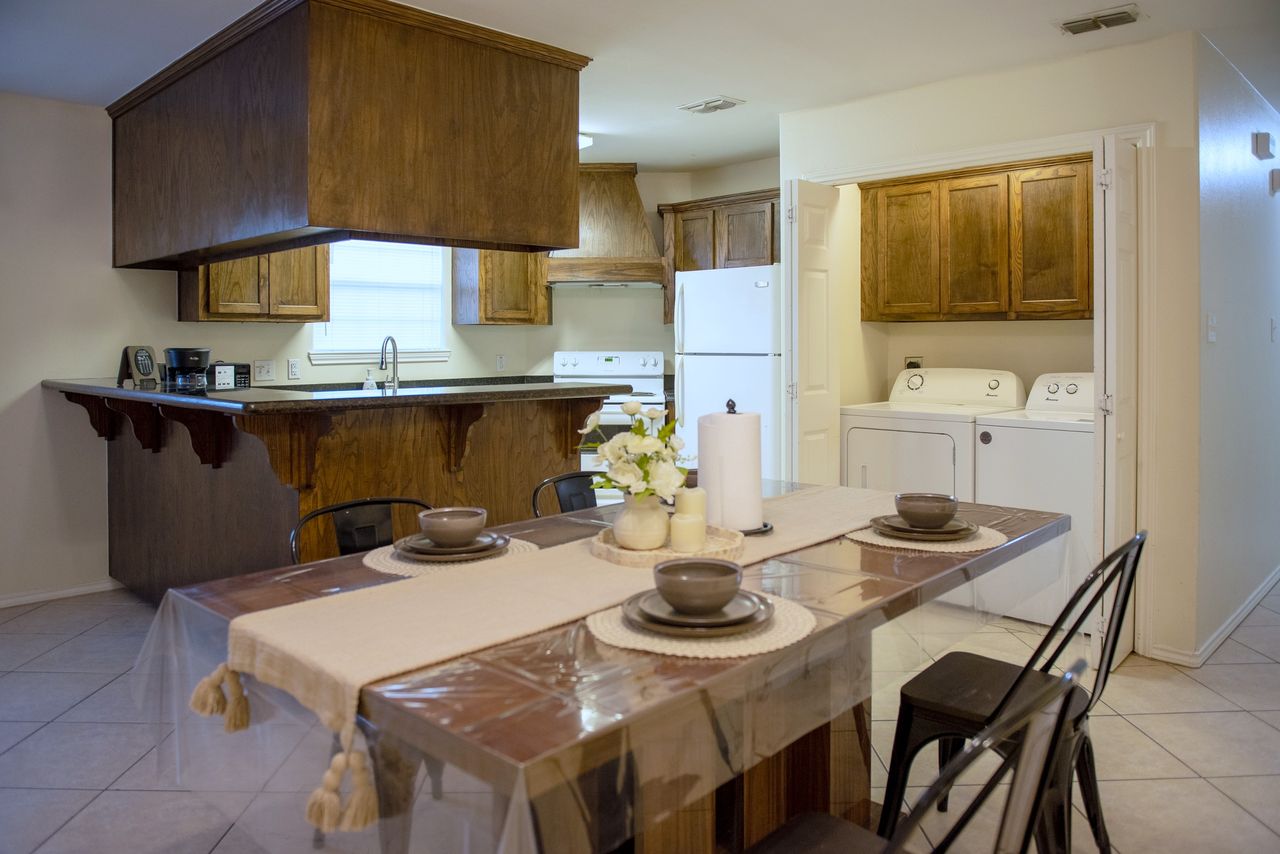 Kitchen with breakfast bar, full-size fridge, and a washer and dryer