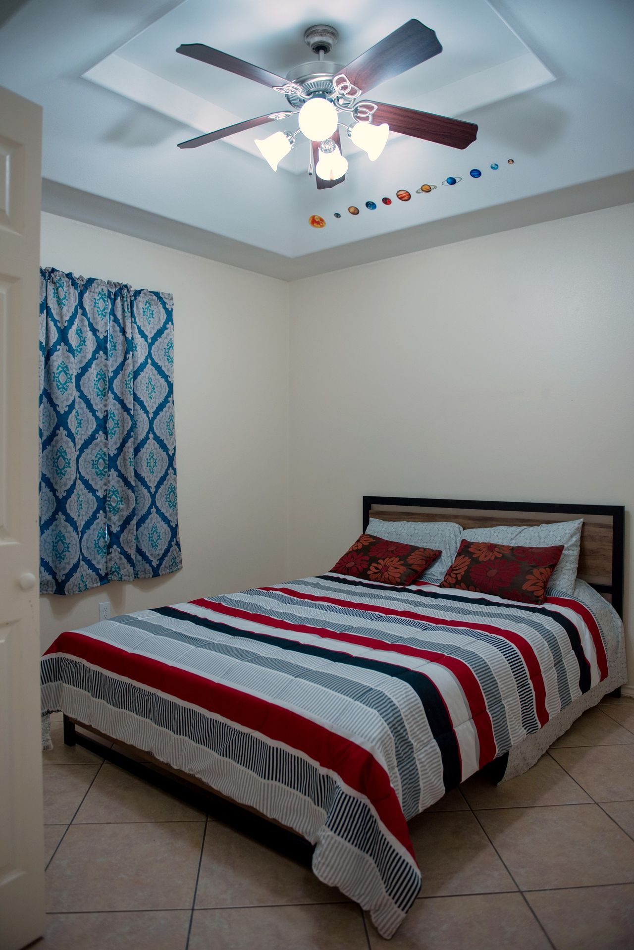 Second bedroom with a large bed and ceiling fan